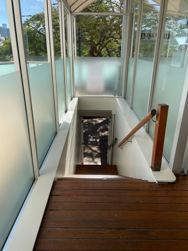 A Staircase With a Wooden Railing and a Glass Wall — Solarmaster in Gold Coast, QLD