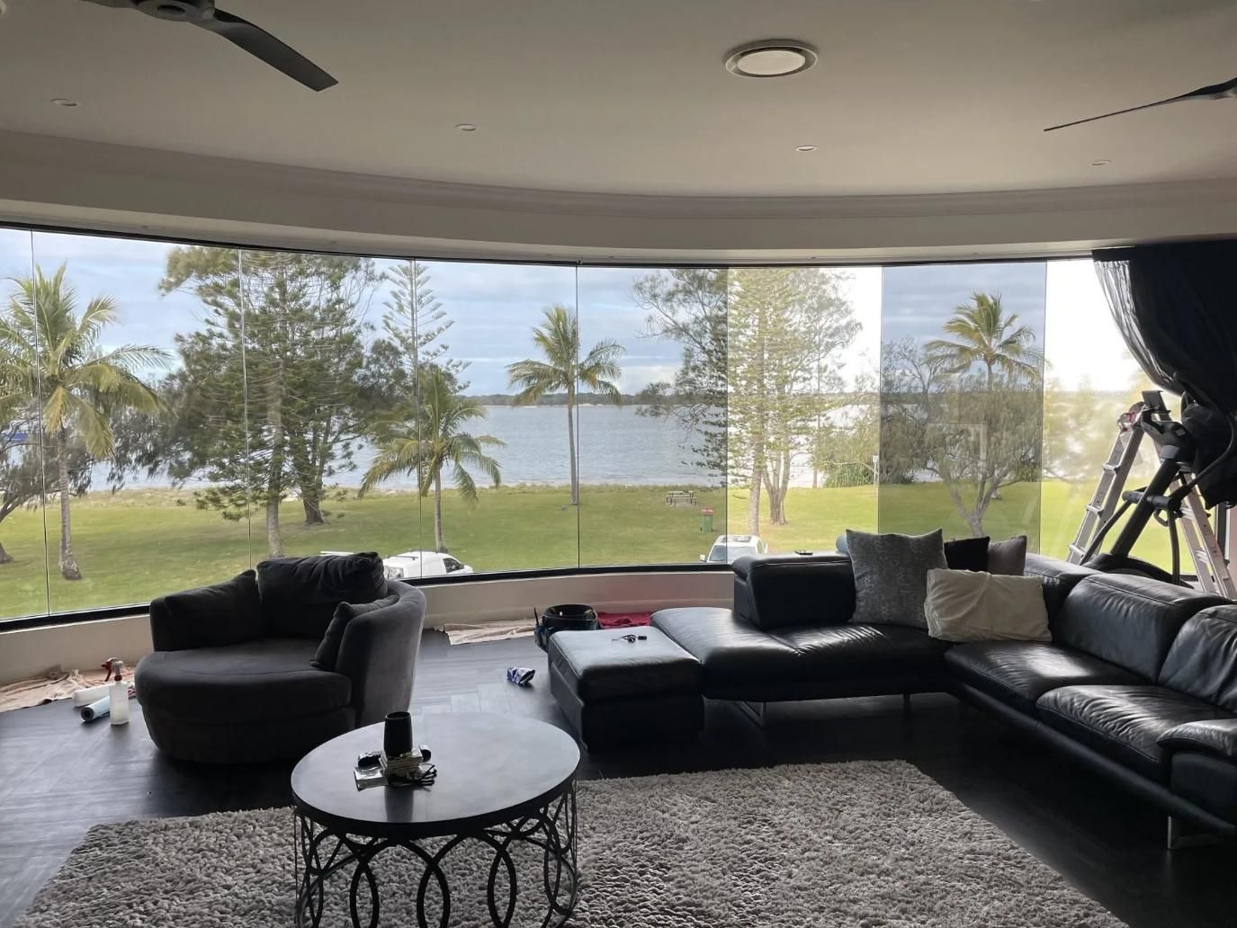 A Living Room with A Couch, Chair, Table and A View of A Lake — Solarmaster in Gold Coast, QLD 