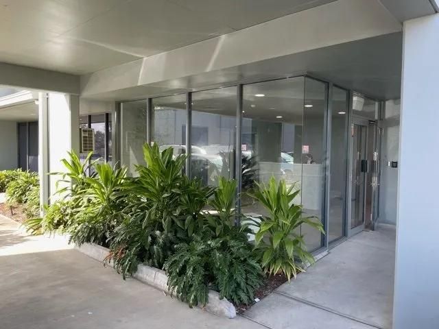 A Building with A Lot of Windows and Plants in Front of It — Solarmaster in Murarrie, QLD