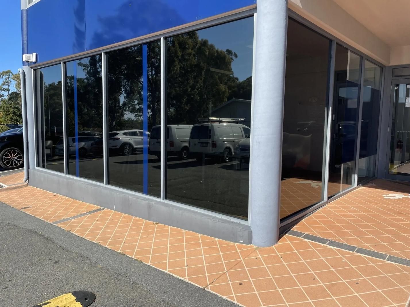 A Building with A Lot of Windows and Cars Parked in Front of It — Solarmaster in Brisbane, QLD