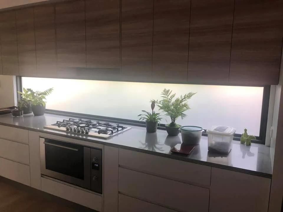 A Kitchen with Potted Plants on The Counter and A Window — Solarmaster in Gold Coast, QLD