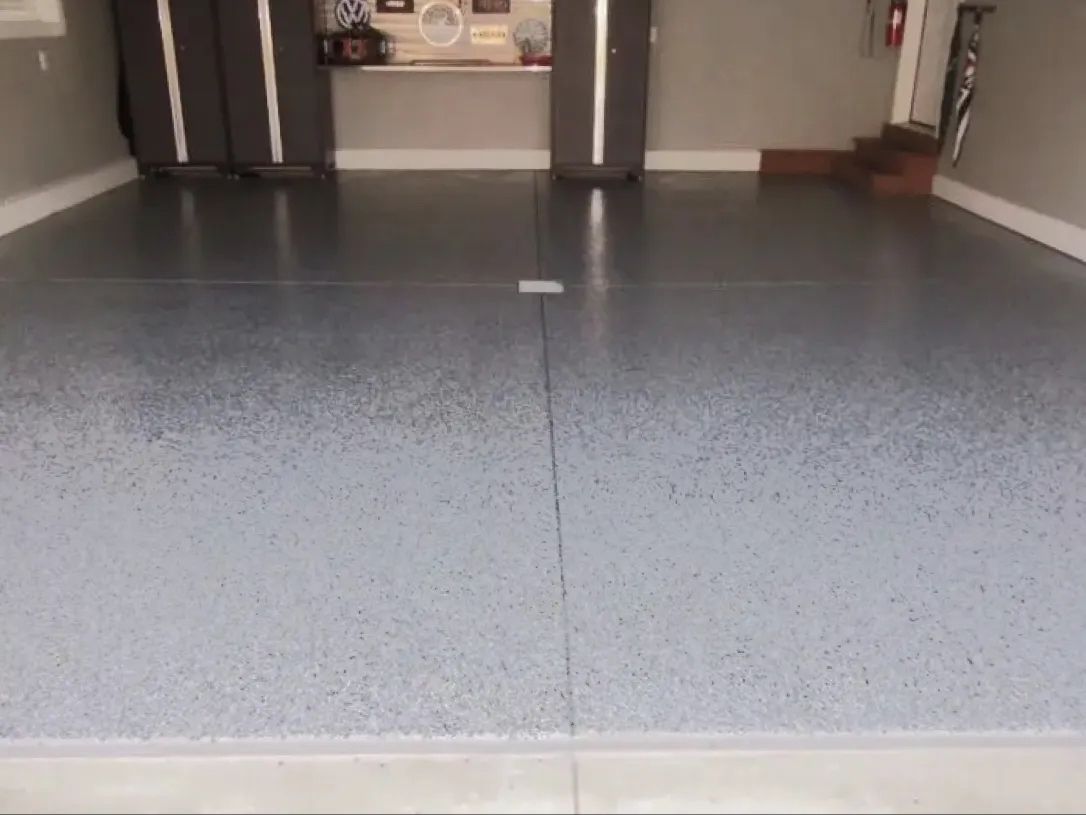 Garage with gray speckled epoxy floor and gray walls.