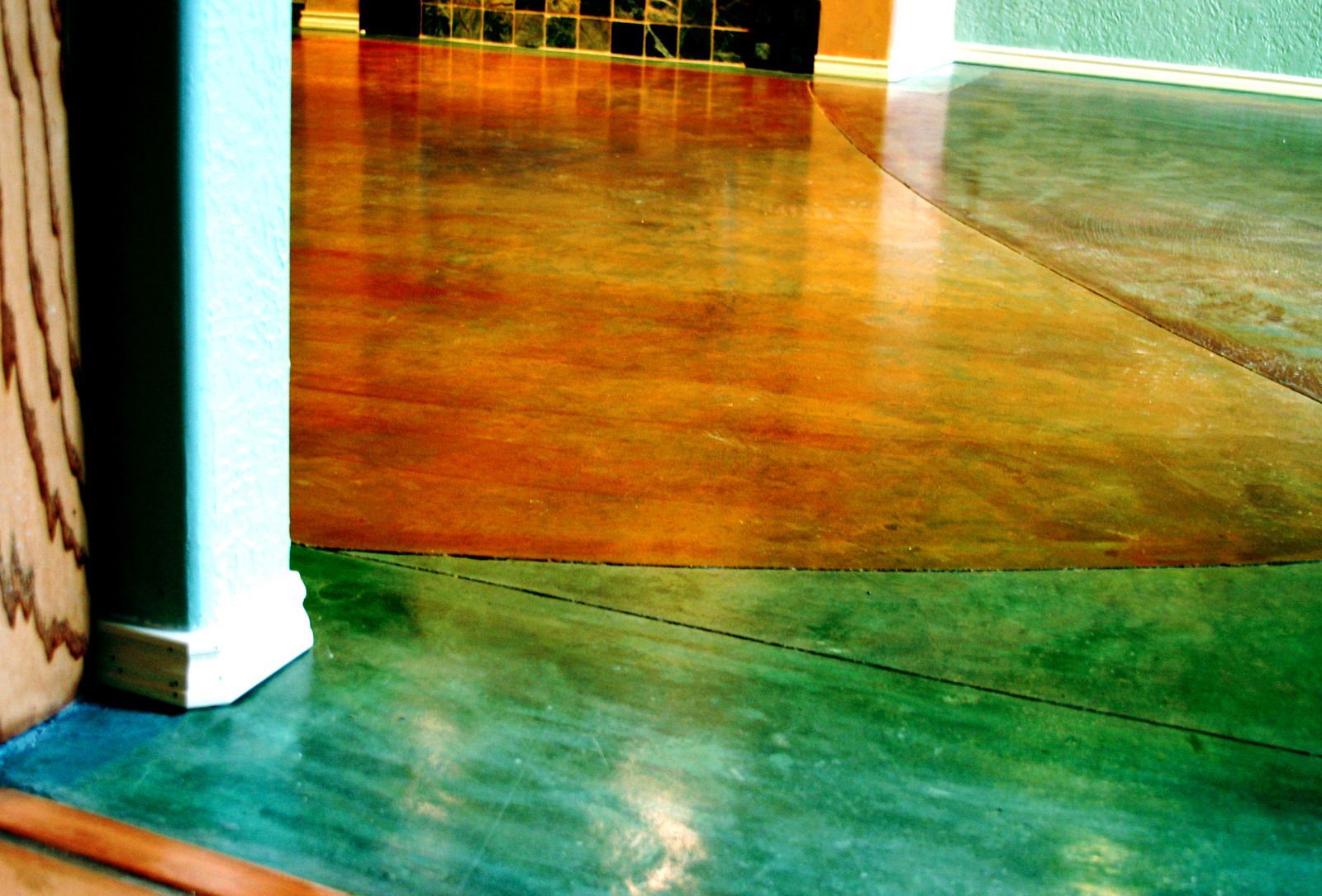 Colorful tiled floor with green and orange sections beside a white column and wall.
