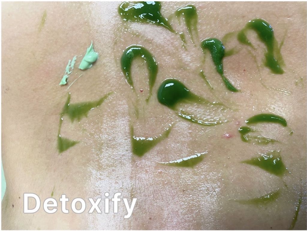 A close up of a person 's back with detoxify written on the bottom