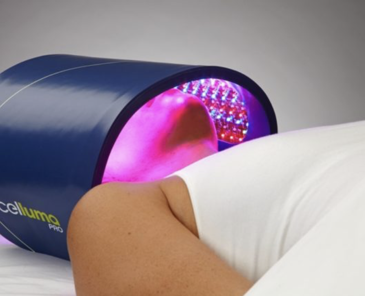 A person laying on a bed with a cellumg device on their head