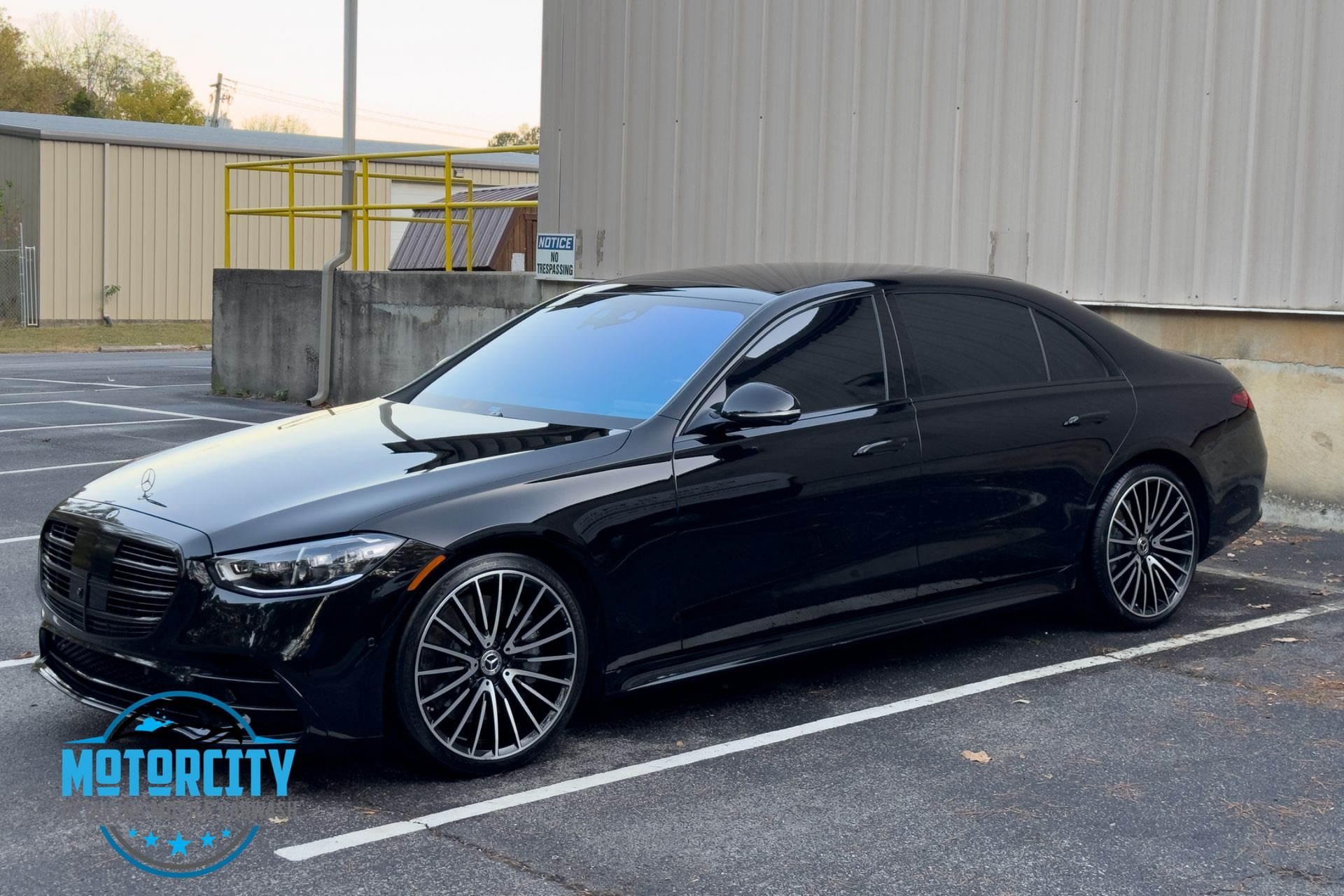 A black mercedes benz s class is parked in a parking lot.
