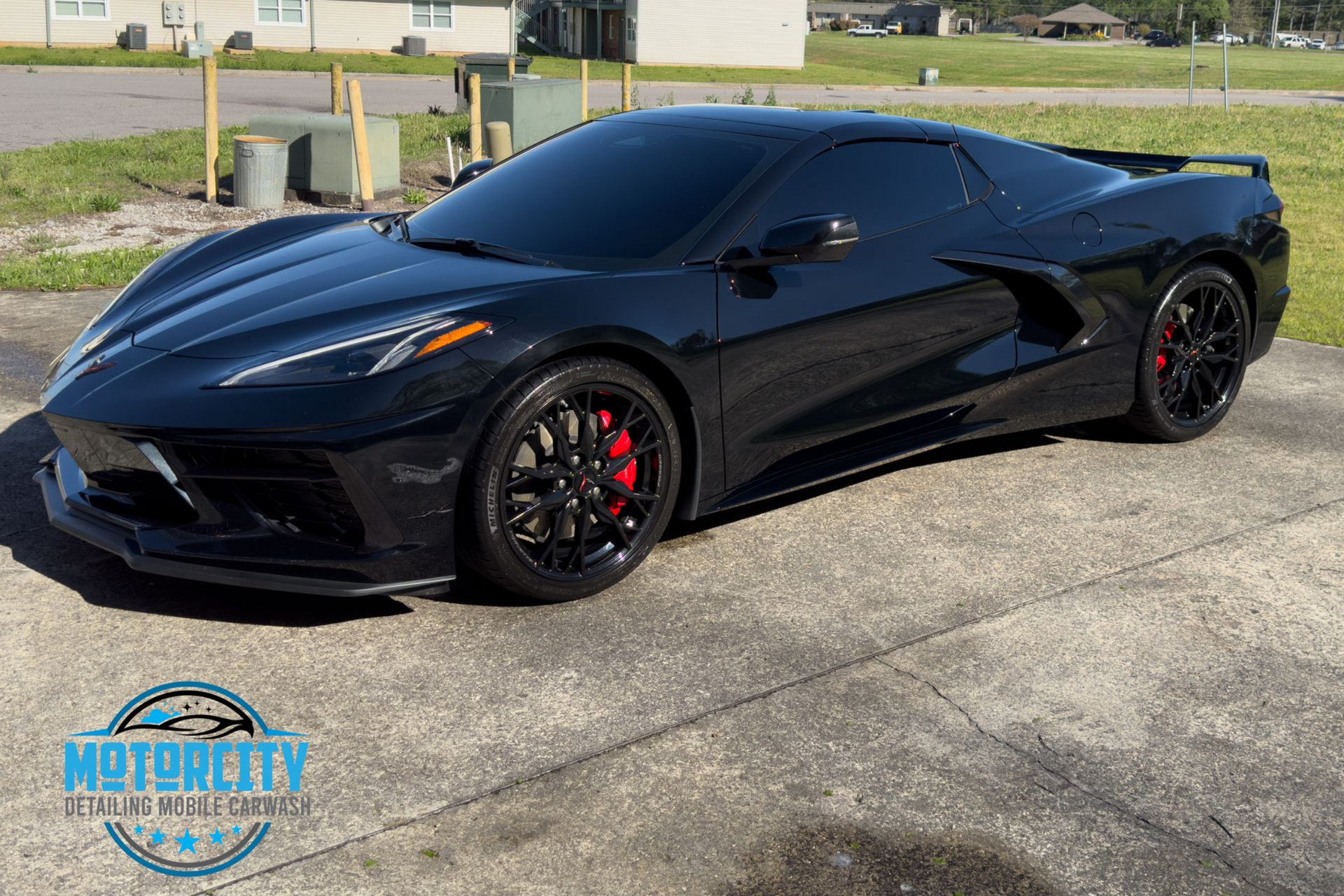 A black sports car is parked on the side of the road.