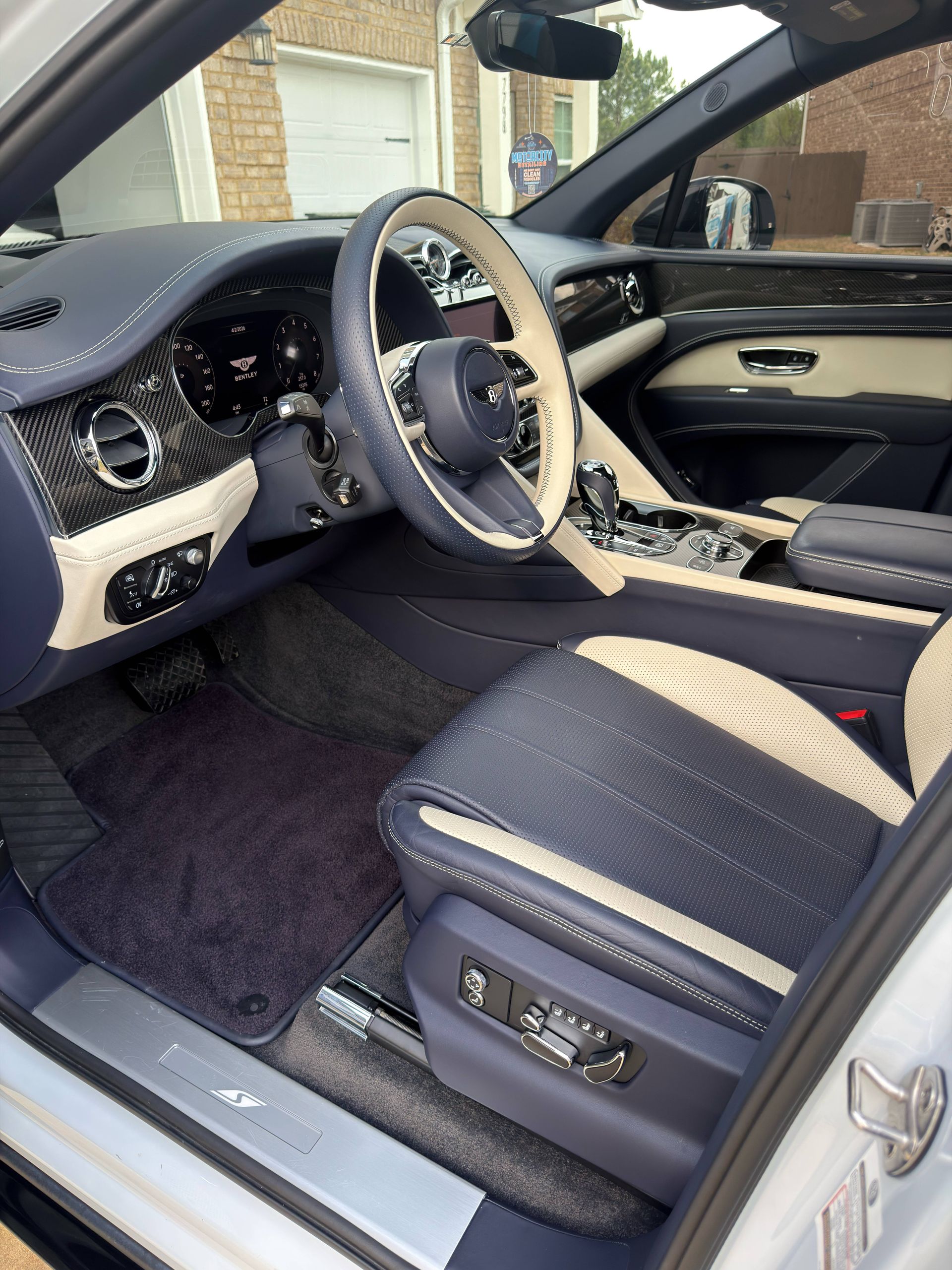 The interior of a car with a steering wheel and seats.