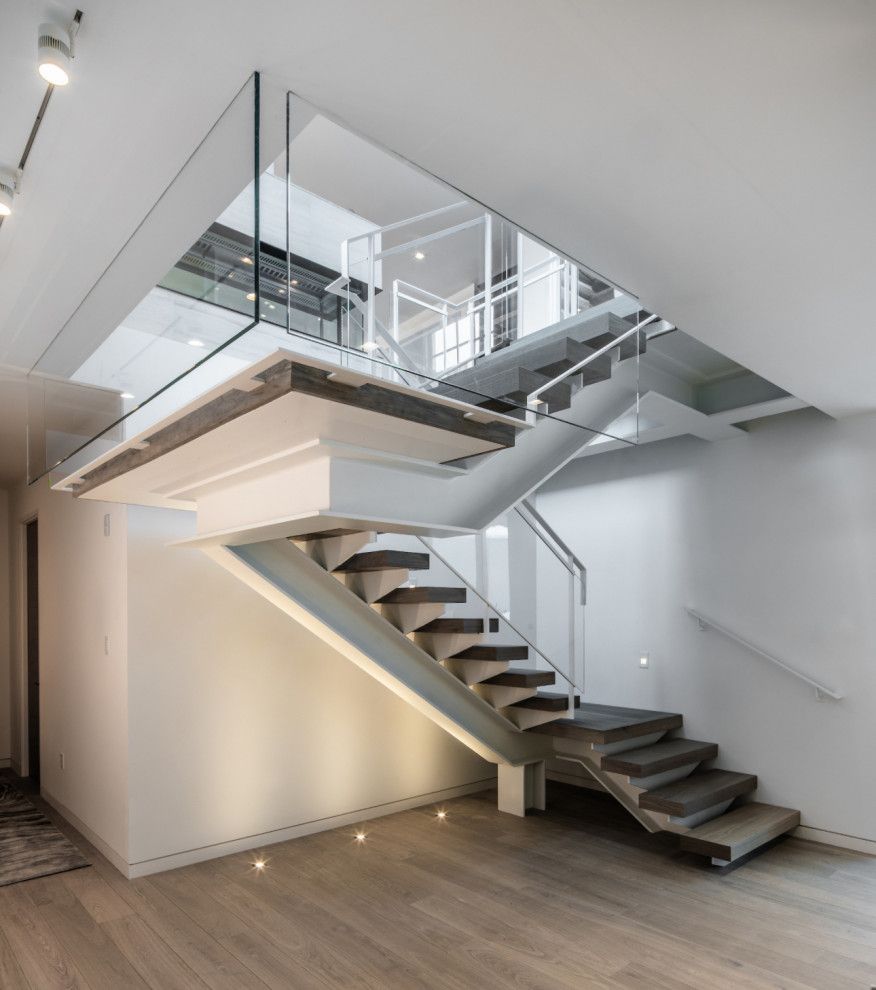 A modern staircase with a glass railing in a house