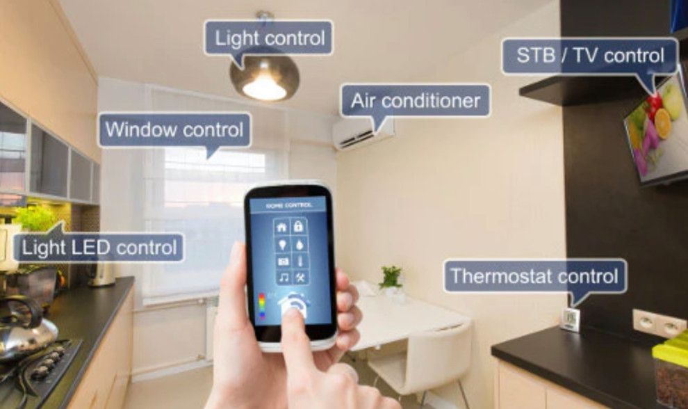 A person is holding a smart phone in their hand in a kitchen.