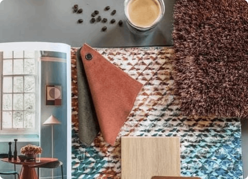 Moodboard met koffie, tapijtstalen en decoratievoorbeelden in warme bruin- en blauwtinten.