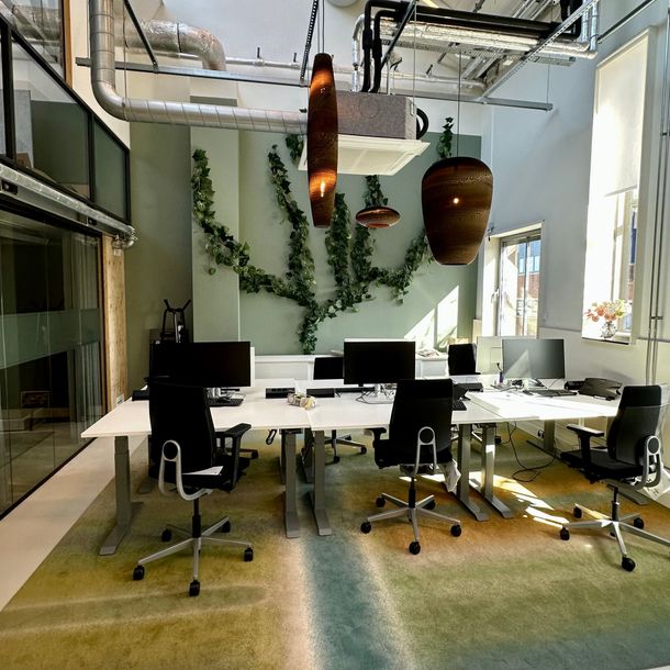 Gezellig, rustiek restaurantinterieur met houten balken, ronde tafels en gestoffeerde stoelen.