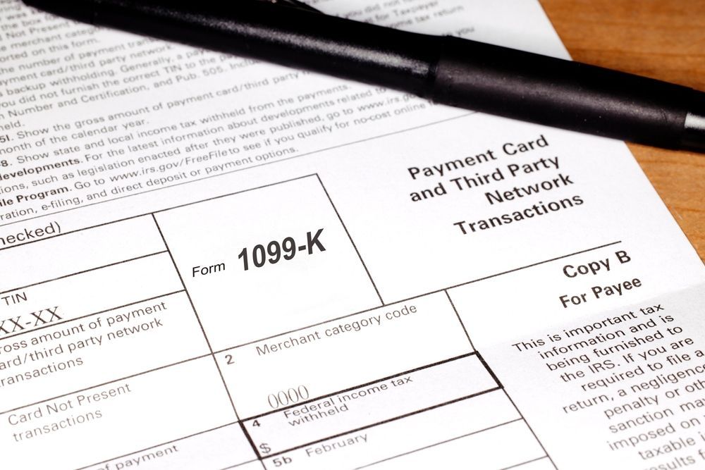 A black pen resting on top of a 1099-K tax form for reporting payment card and third-party network transactions.