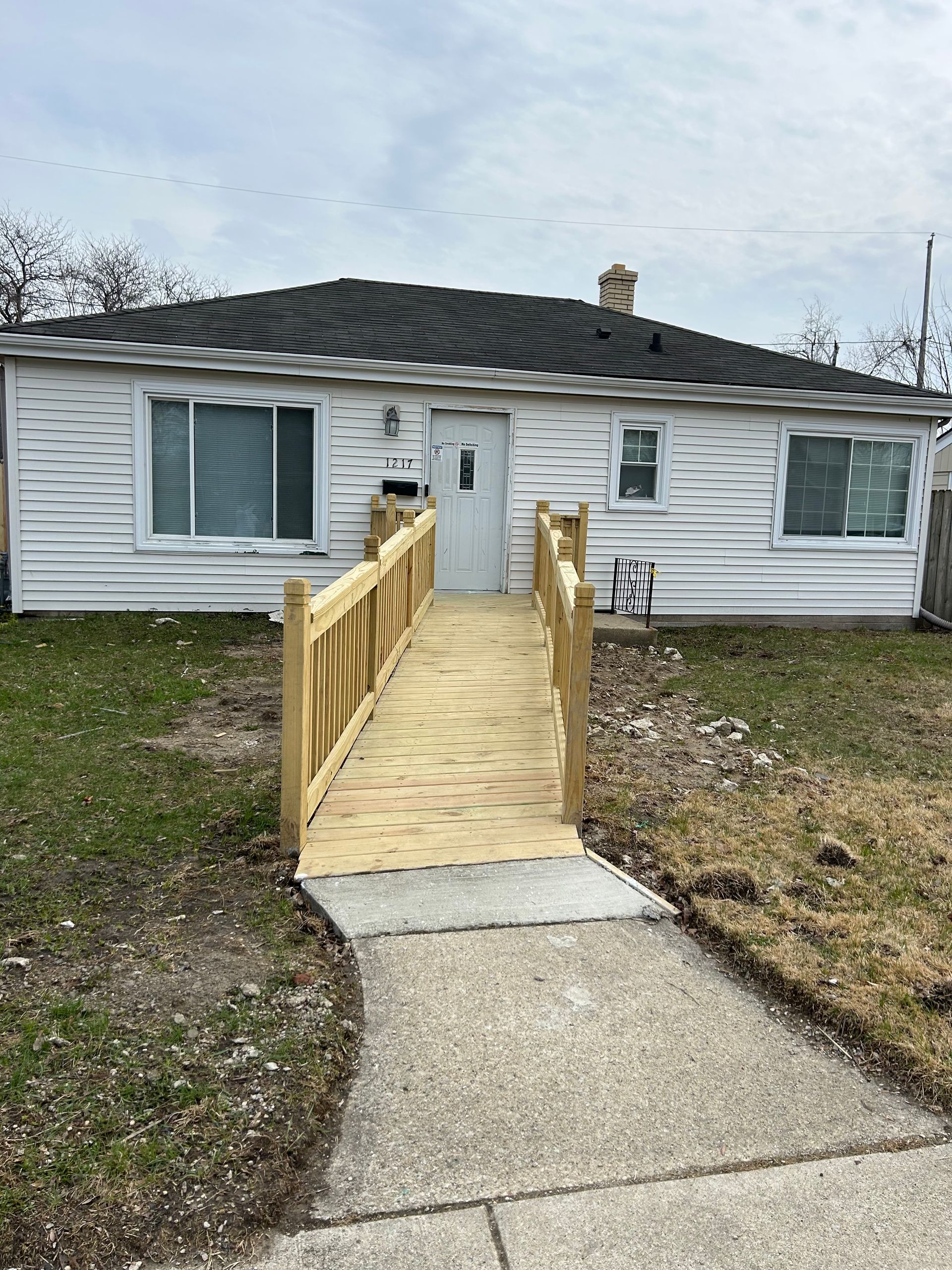 Single-story house with a wooden wheelchair ramp leading to the front door.