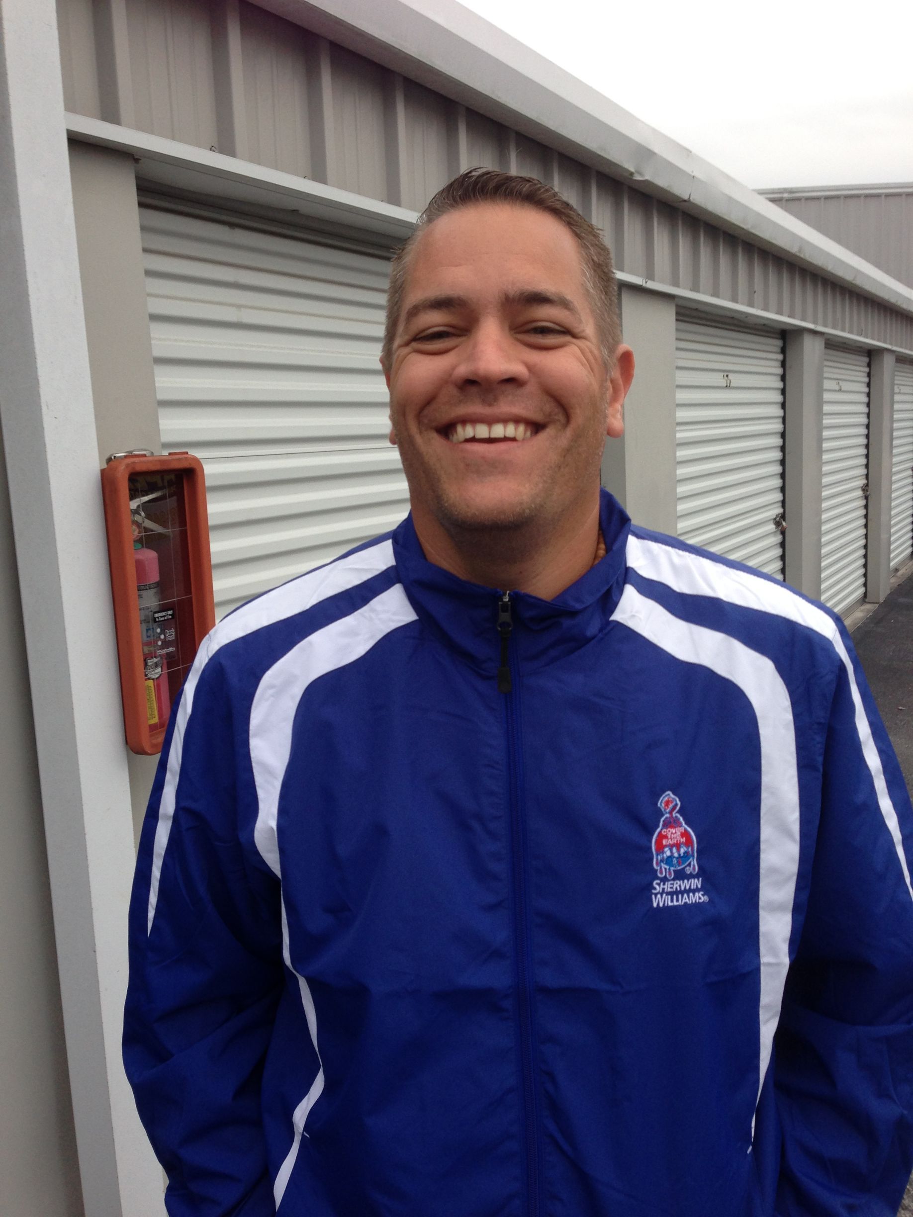 A man wearing a blue and white jacket is smiling