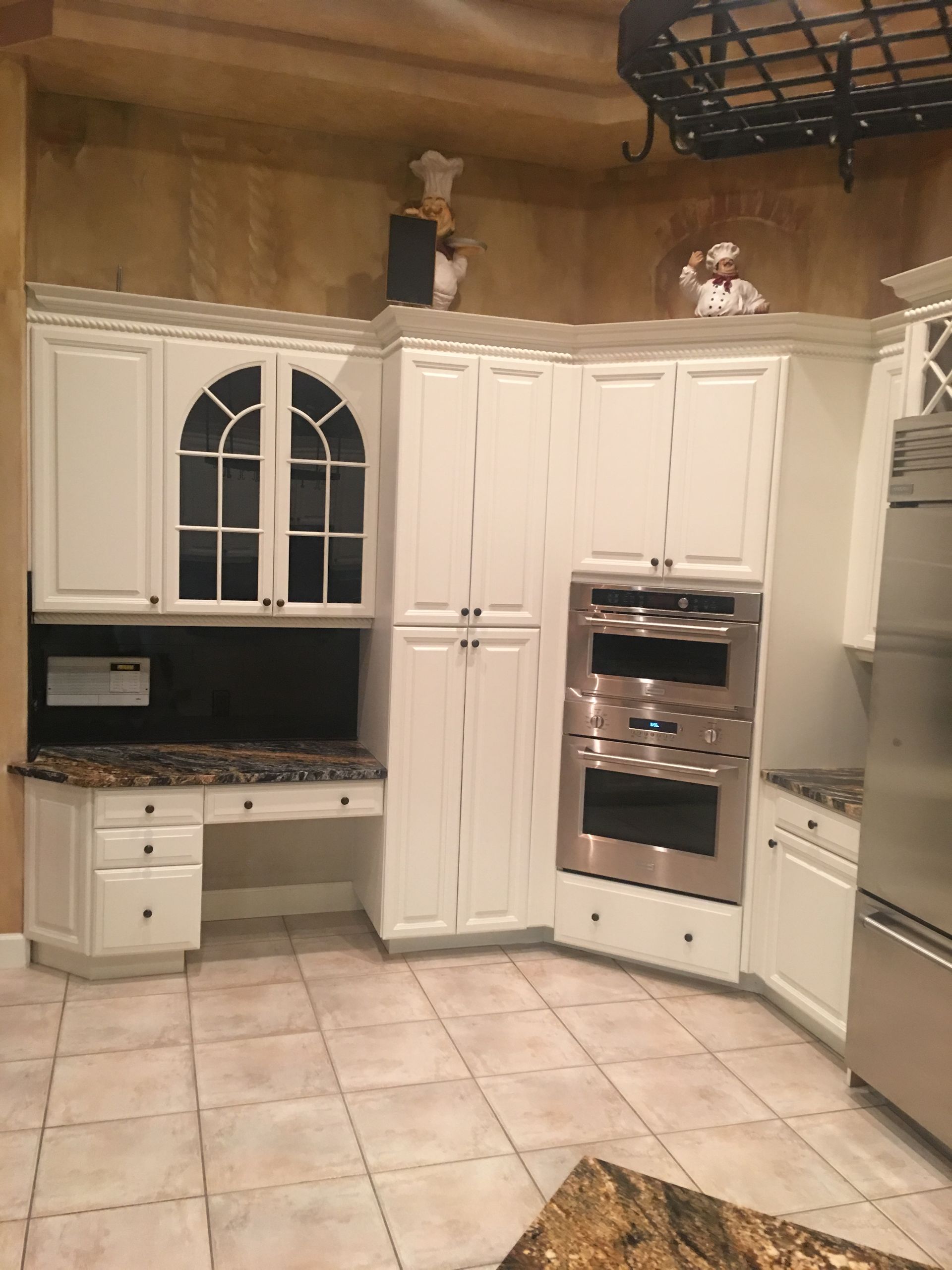 A kitchen with white cabinets and stainless steel appliances