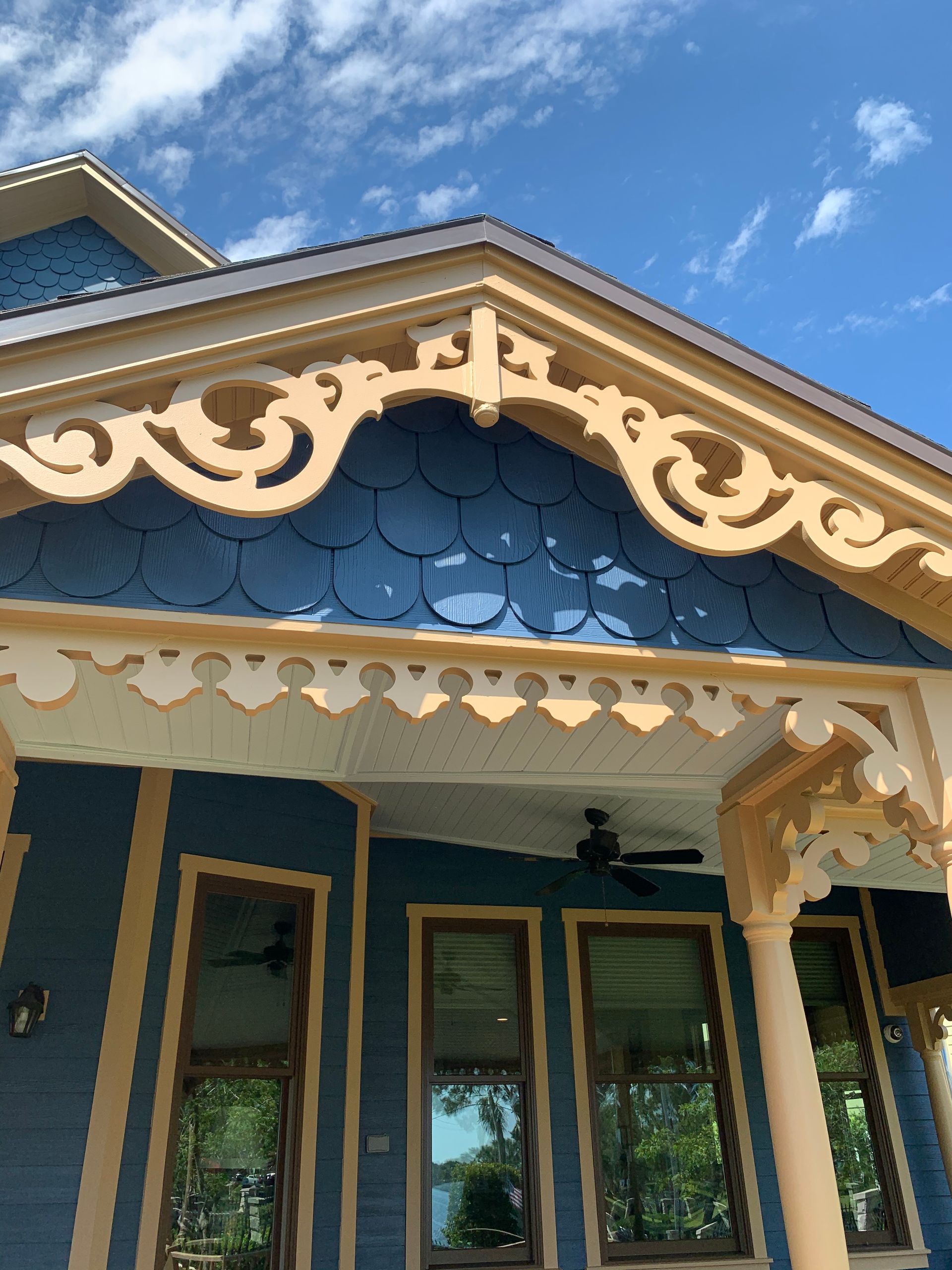 A blue house with a porch and a blue sky in the background