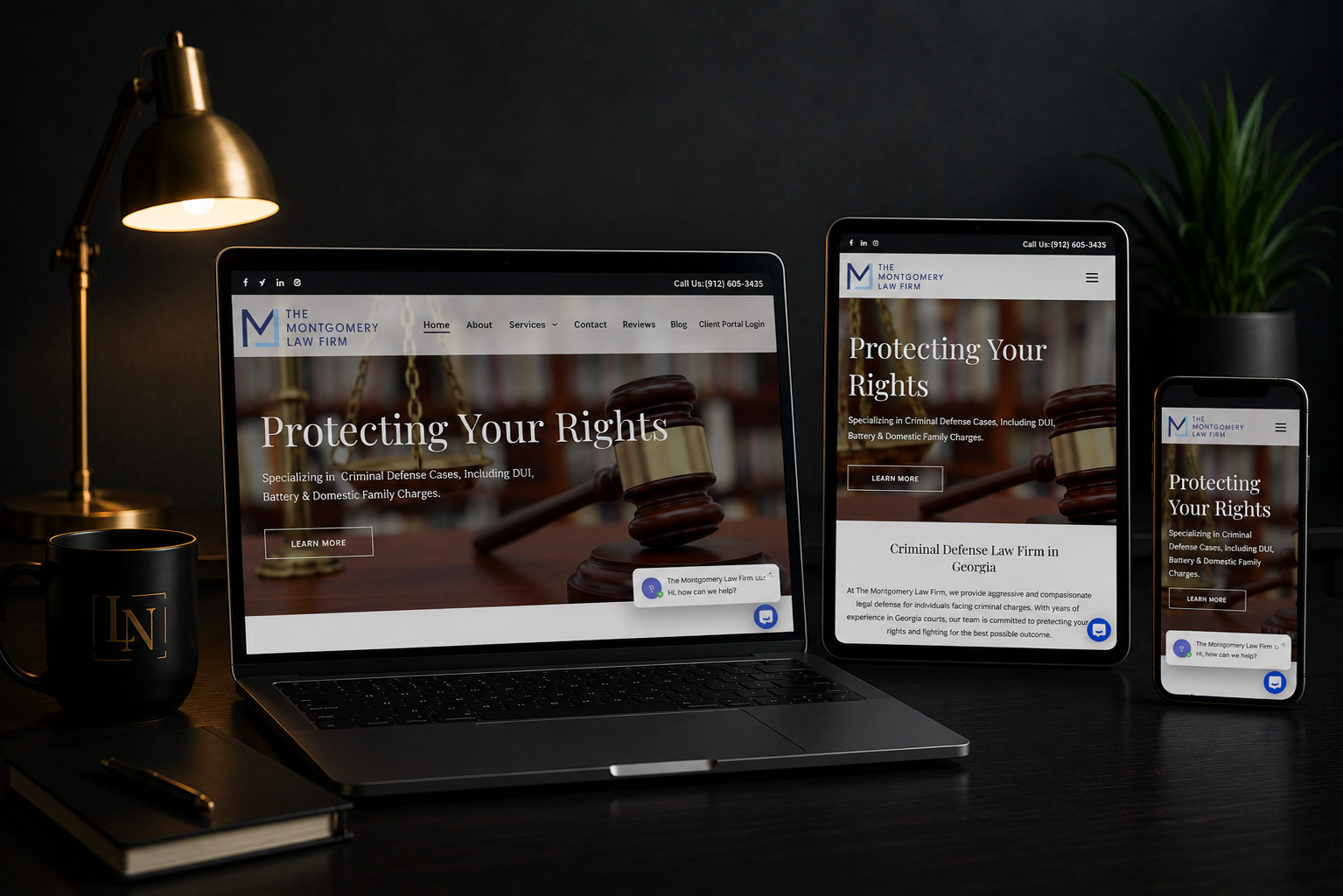 Laptop, tablet, and phone on a desk displaying a website in a dimly lit workspace.
