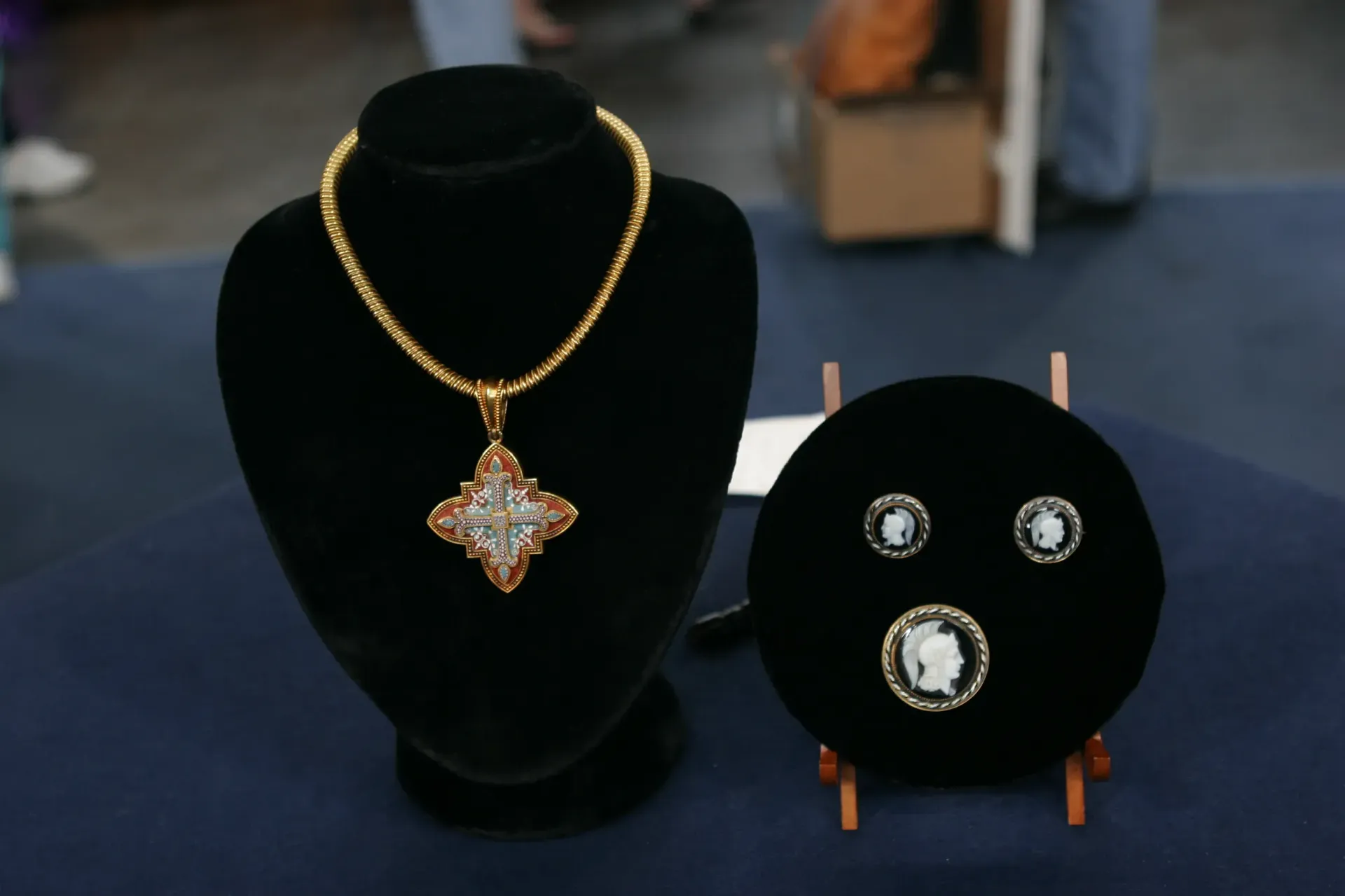 A black display tray filled with various gold-toned rings and decorative jewelry pieces.