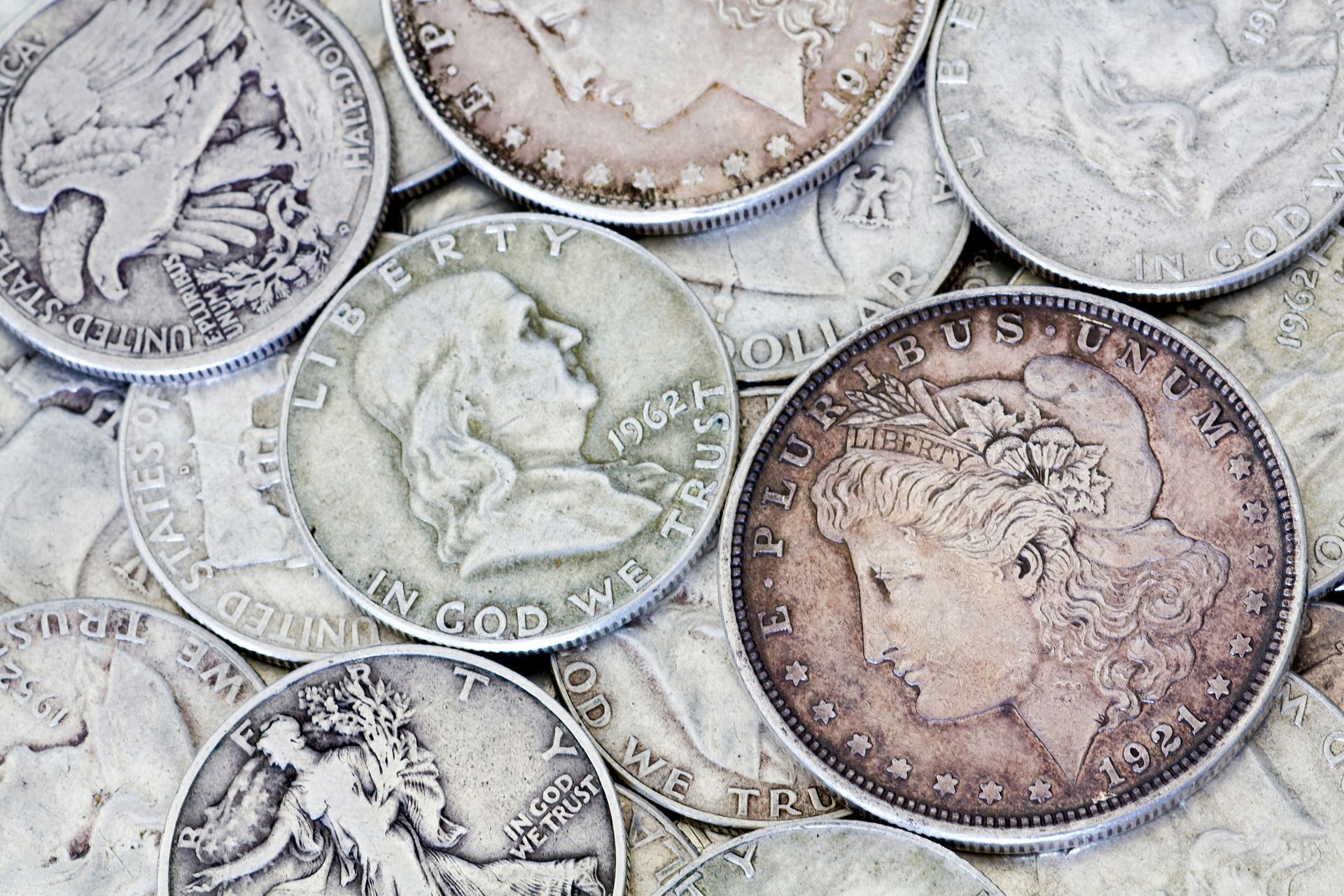 A collection of various vintage and modern United States gold coins resting on a dark, wooden surface.