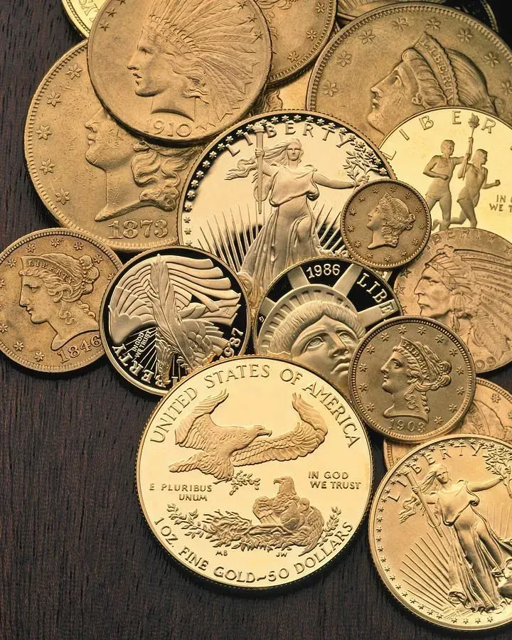 A collection of various gold American coins, including Liberty heads, Indian heads, and American Gold Eagle bullion coins.