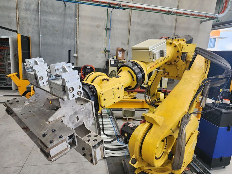 A yellow robot is working on a piece of metal in a factory — Industrial Automation Australia in Eagle Farm, QLD