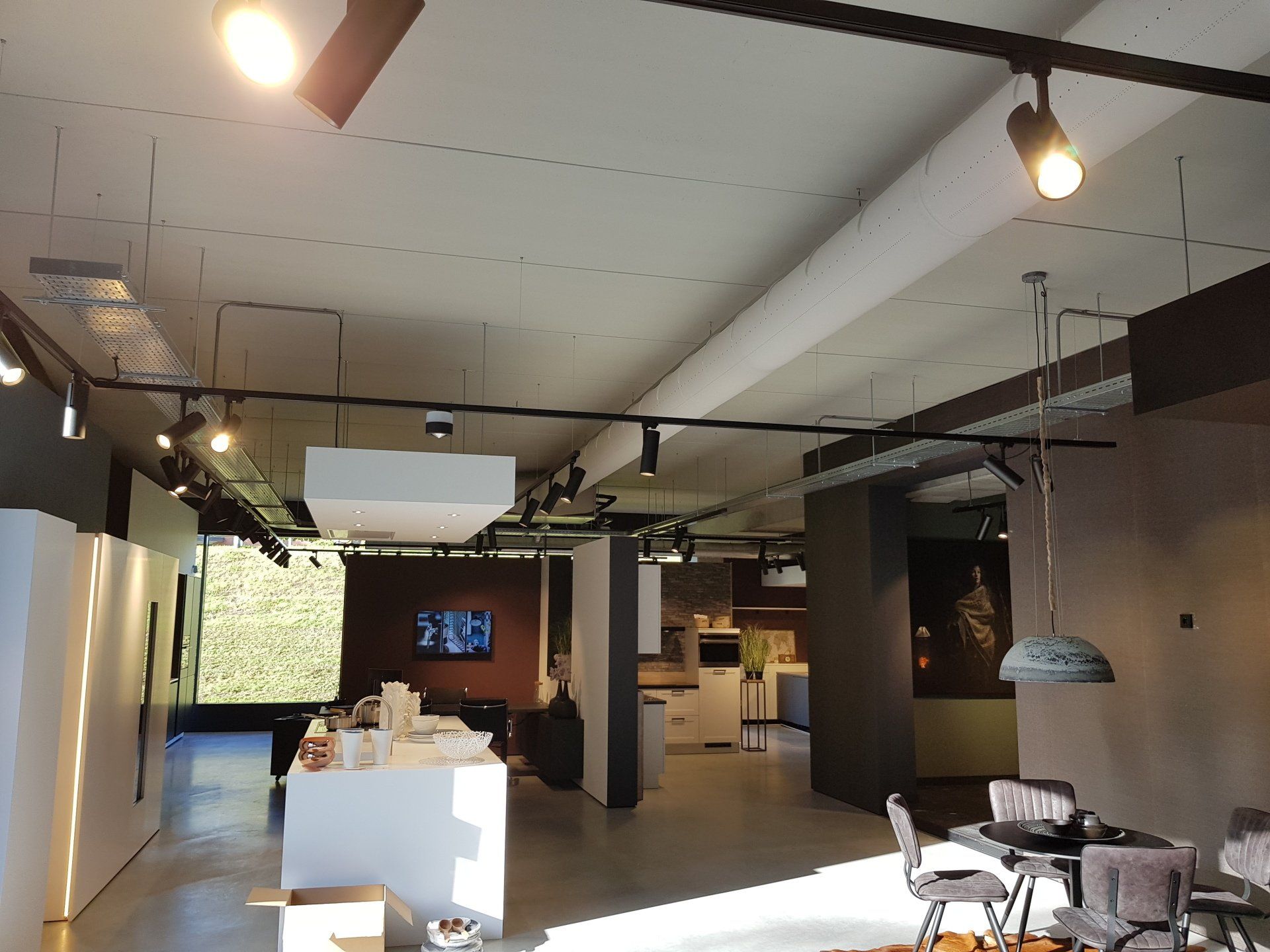 Een grote shoroom met veel lampen en airsocks/luchtverdeelslangen die aan het plafond hangen