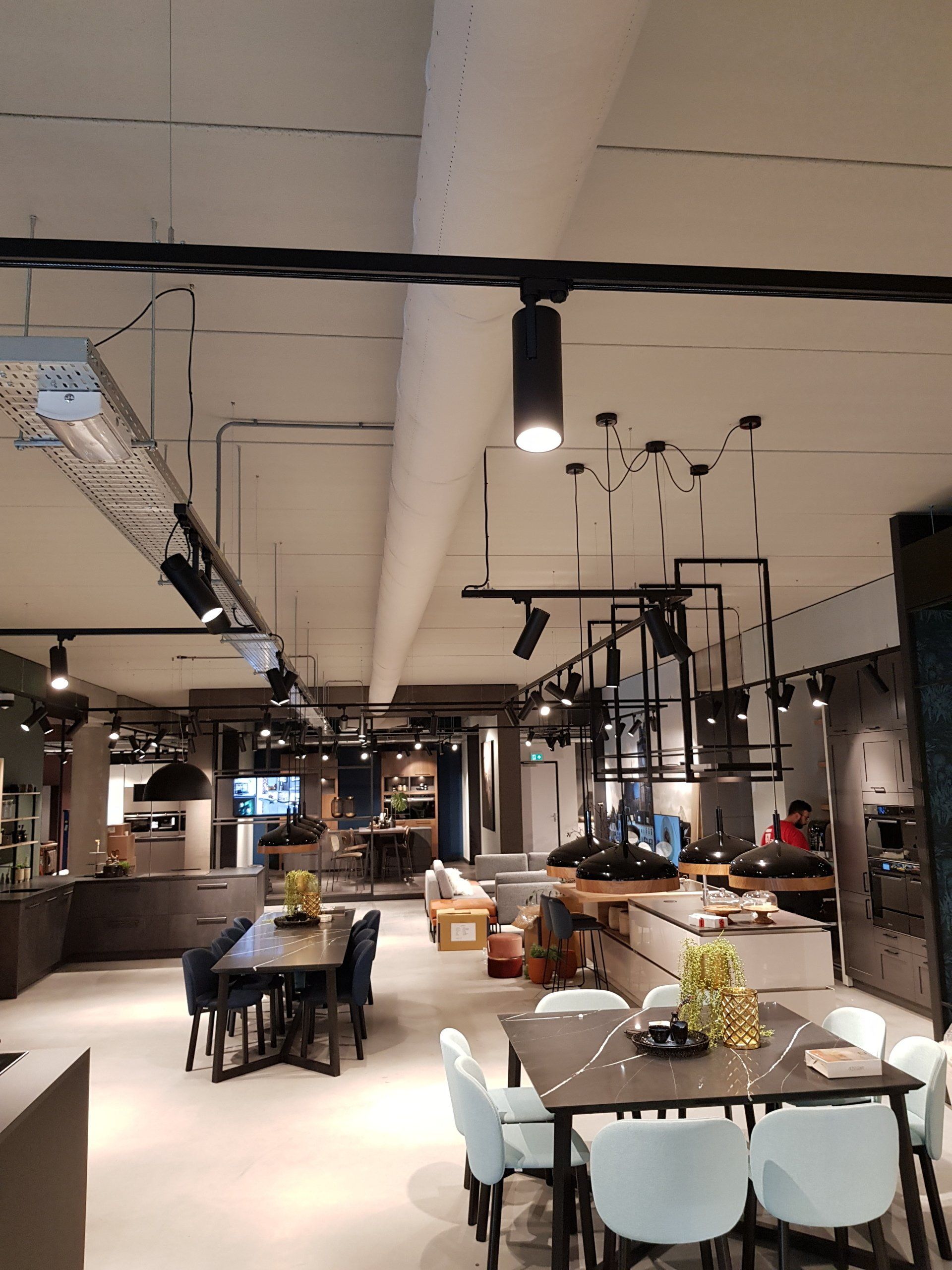 Een grote showroom met tafels en stoelen en airsock/luchtverdeelslang erin