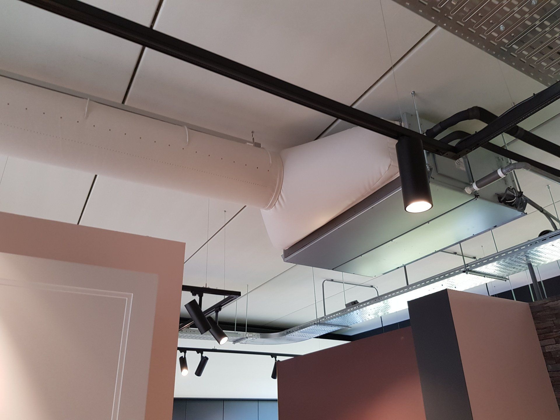 Een plafond met veel lampen en een airsock/luchtverdeelslang met kanaal airconditioner eraan