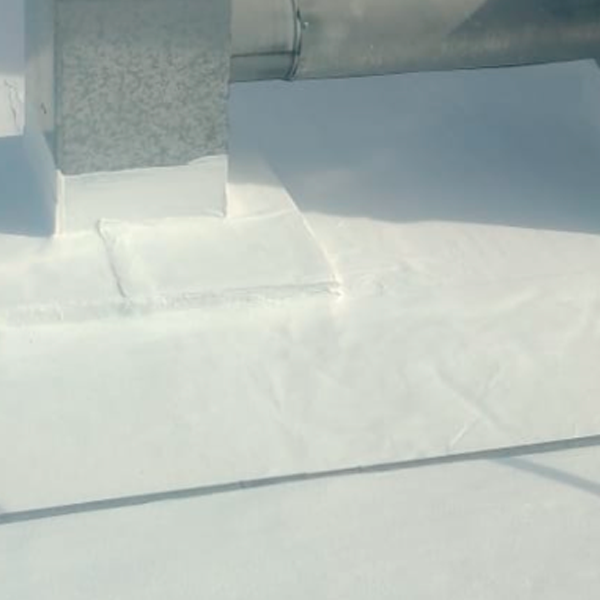 Suelo cubierto de nieve junto a una estructura de hormigón bajo la luz del sol.