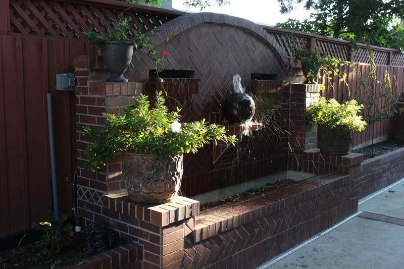 A brick wall with a fountain in the middle of it