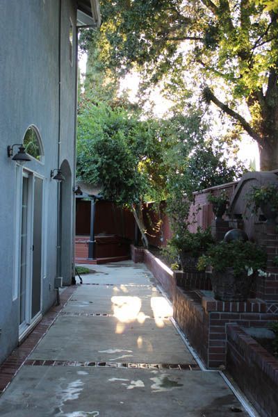 A narrow walkway between two buildings with trees in the background
