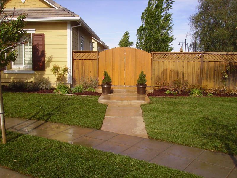 A house with a wooden fence and a walkway leading to it