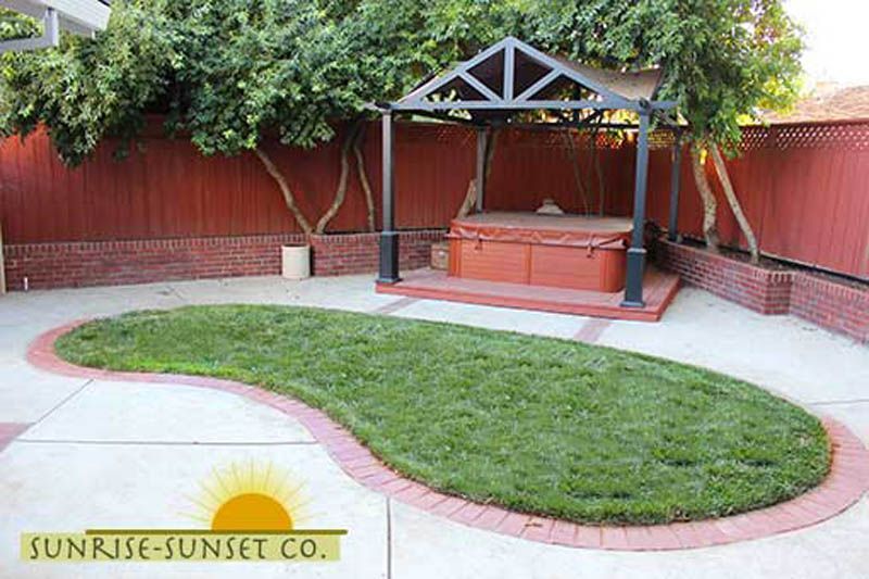 A backyard with a gazebo and a hot tub.