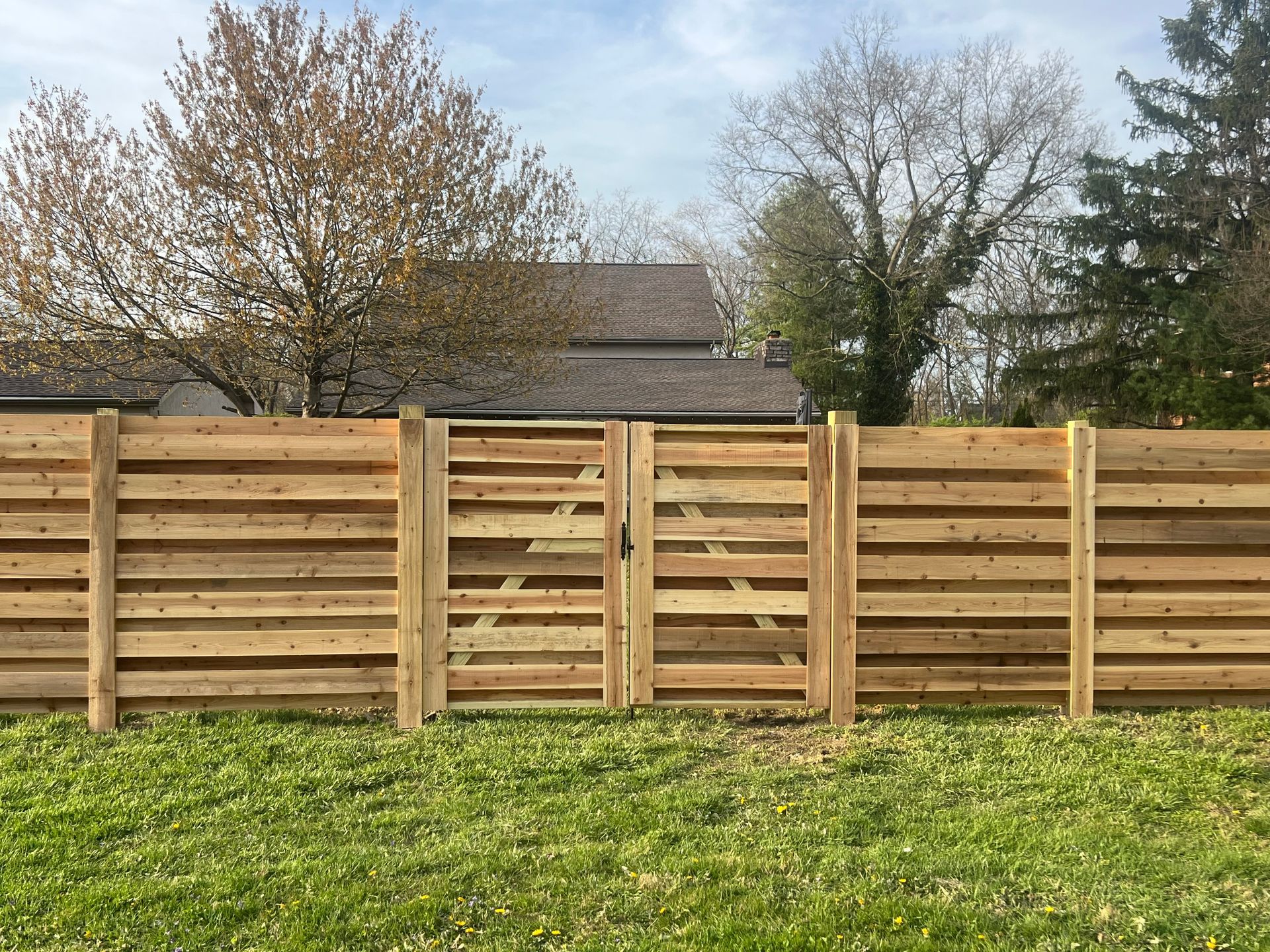 Wooden fence with gate in front of a house.
