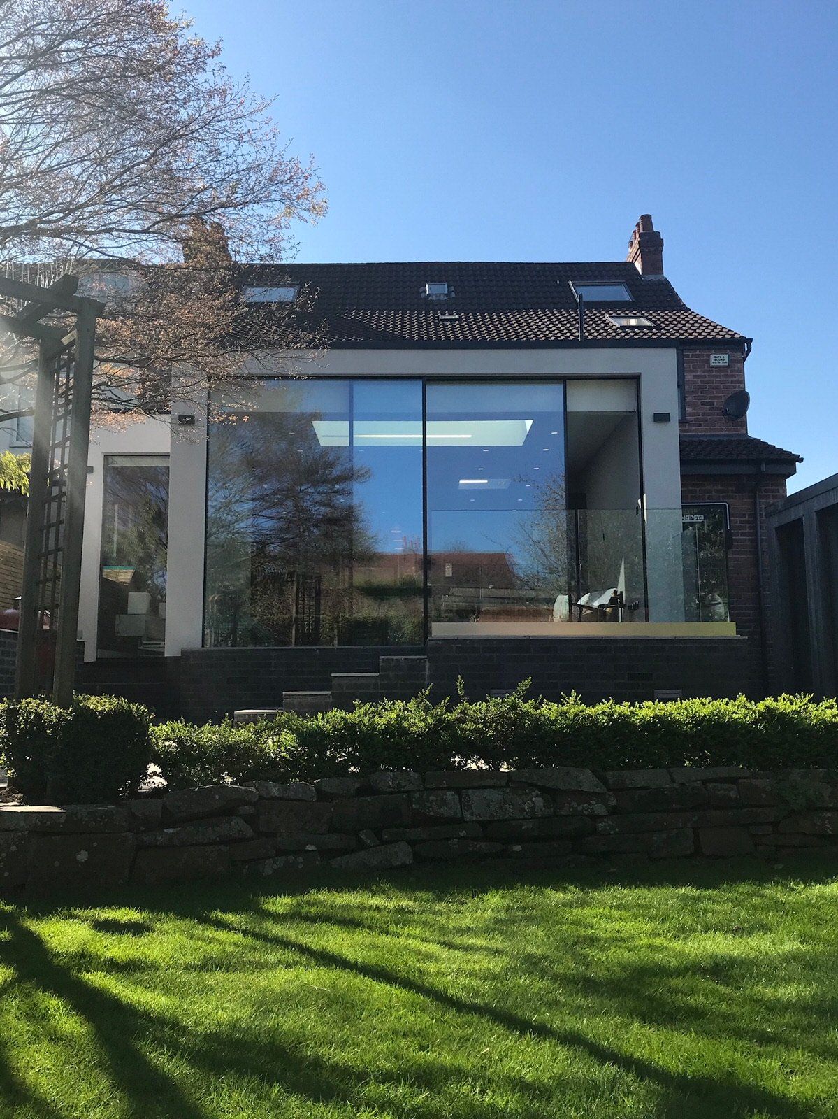 Contemporary rendered extension with frameless, floor-to-ceiling glazing