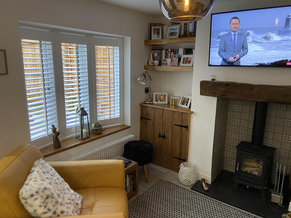 Interior view of lounge showing log-burning fireplace integrated into turnkey renovation