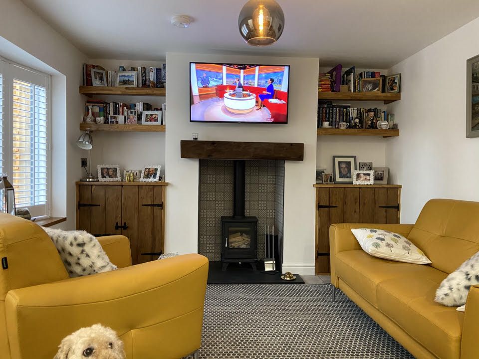 Lounge with log-burning fireplace in renovated Knutsford terrace cottage by Rawlinson Construction