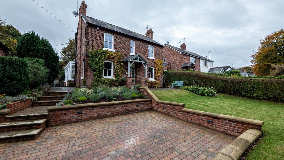 Exterior view of a renovated property in Cheshire with a remodelled driveway and new boundary walls, by Rawlinson Construction 