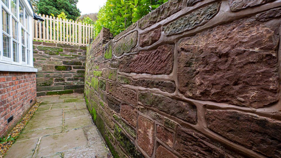 Close-up of natural sandstone retaining wall craftsmanship in Cheshire renovation by Rawlinson Contstuction 
