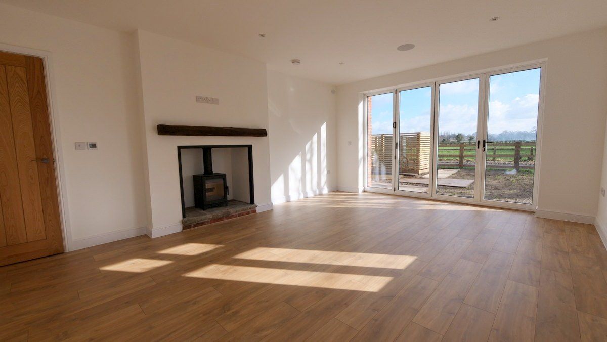 Spacious open plan living spacer in a traditional style new build home with a log burner and natural light