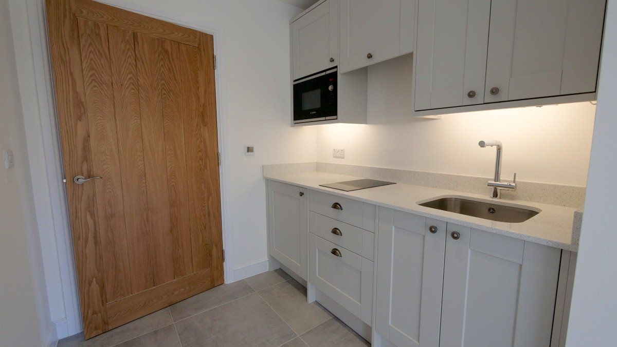 Utility room with neutral decor in farmhouse style new build home in Cheshire