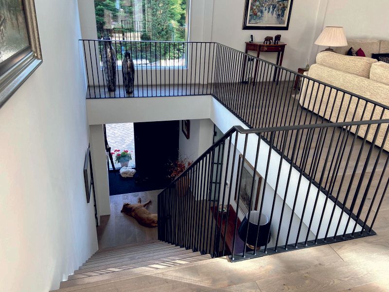 Modern staircase integrated into refurbished timber-frame home by Rawlinson Construction