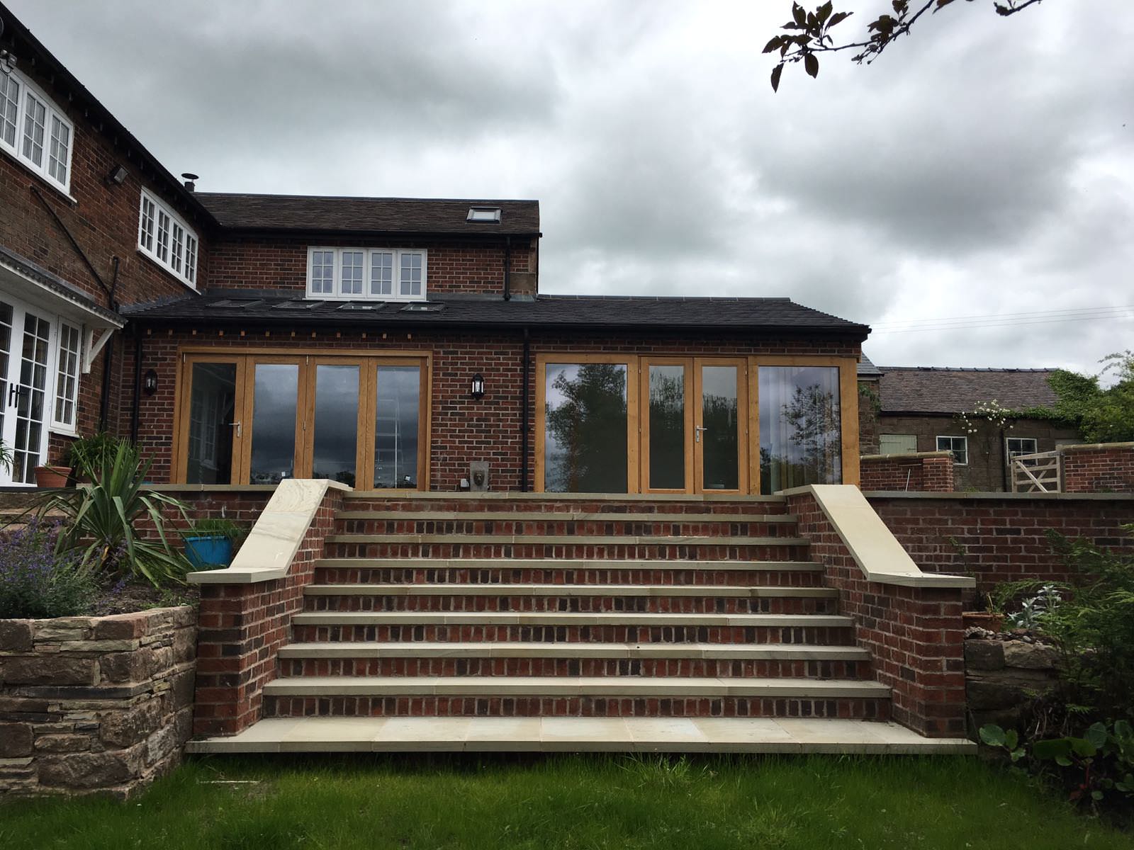 Rear exterior of Cheshire home featuring double kitchen extension with large glazing and garden access