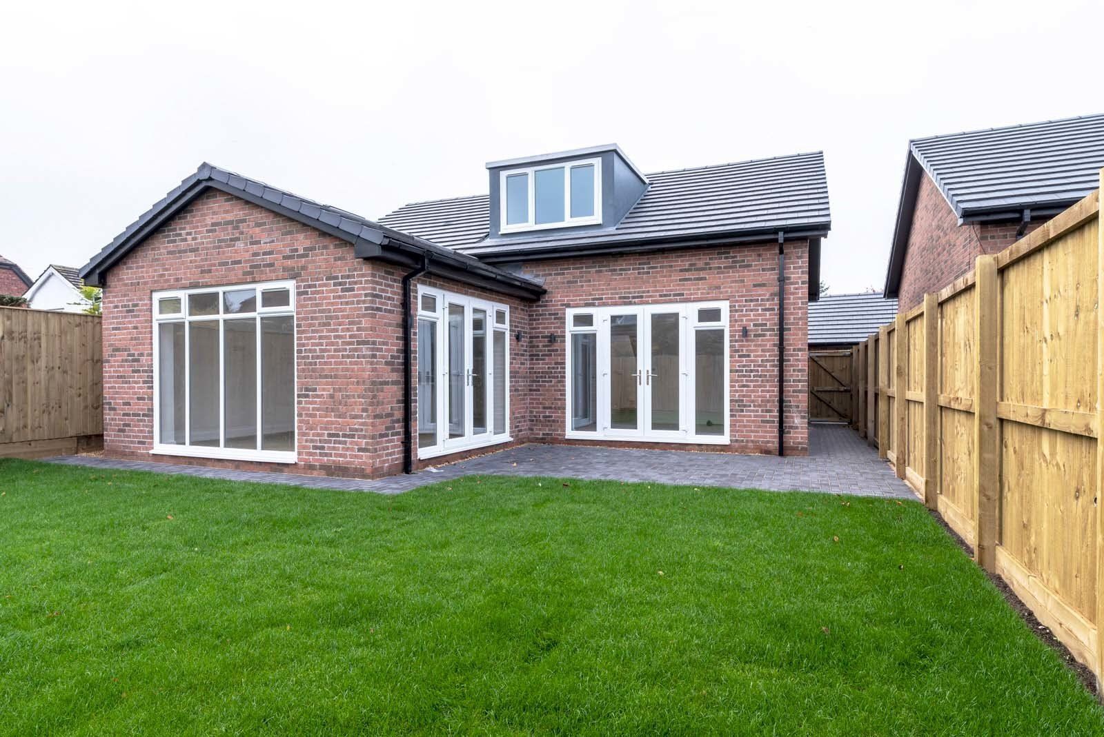 Landscaped gardens surrounding newly built dormer bungalow in Cheshire by Rawlinson Construction