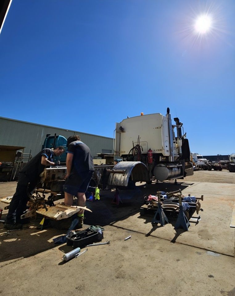 Two Men Are Working On A Semi Truck In A Parking Lot — Central Diesel Services In Alice Springs, NT