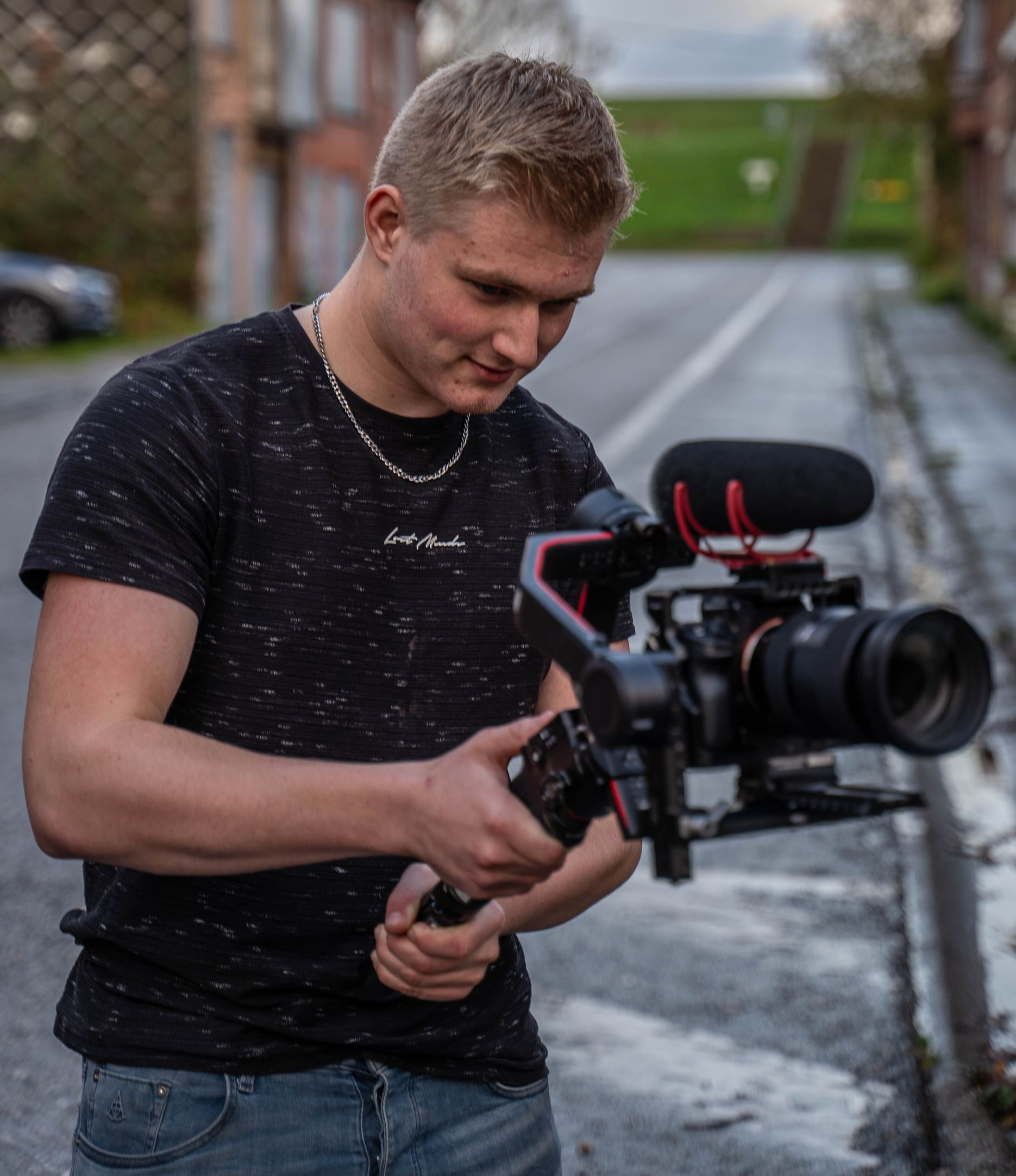 Een man filmt met een camera op een stabilisator in een buitenomgeving.