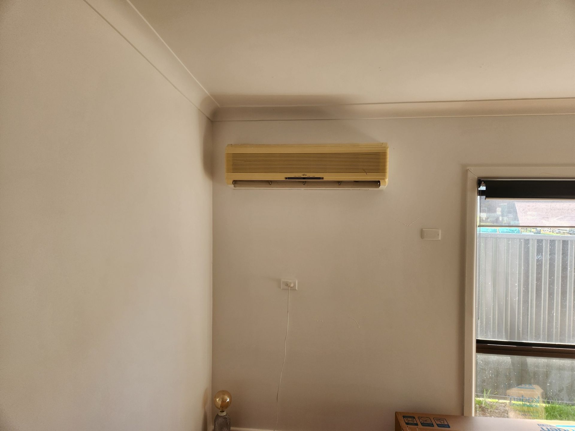 Beige Wall-mounted Air Conditioner Unit Positioned — Unger Air in Manilla, NSW