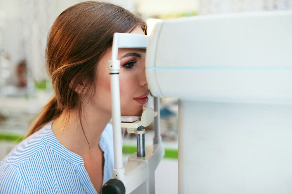 A Woman Is Getting Her Eyes Examined By An Ophthalmologist — Eye Supply In Mareeba, QLD