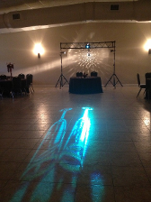 A room lit by a mirrored disco ball, with shadows of two champagne glasses in the foreground.
